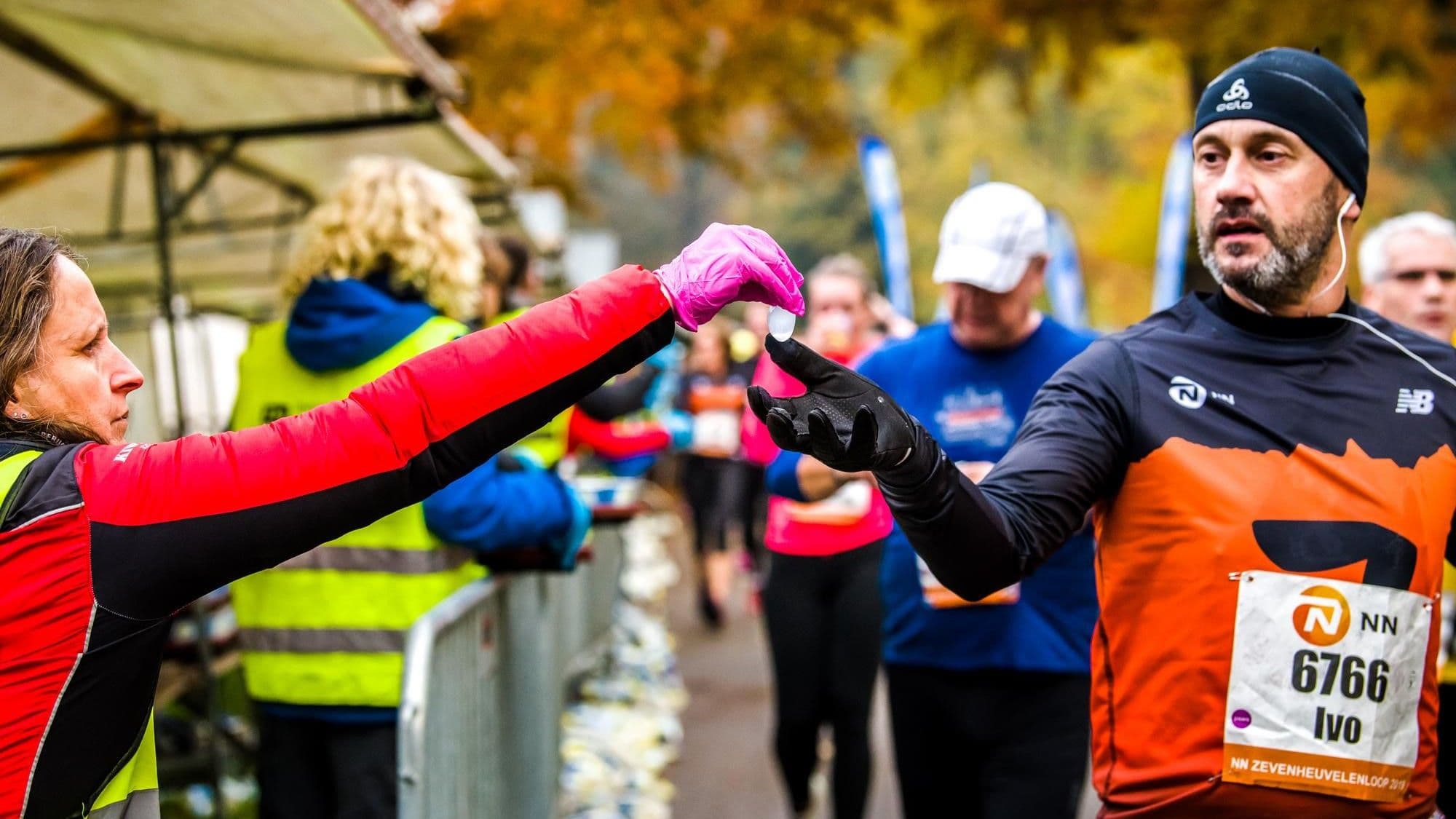 hardloper neemt water aan tijdens wedstrijd