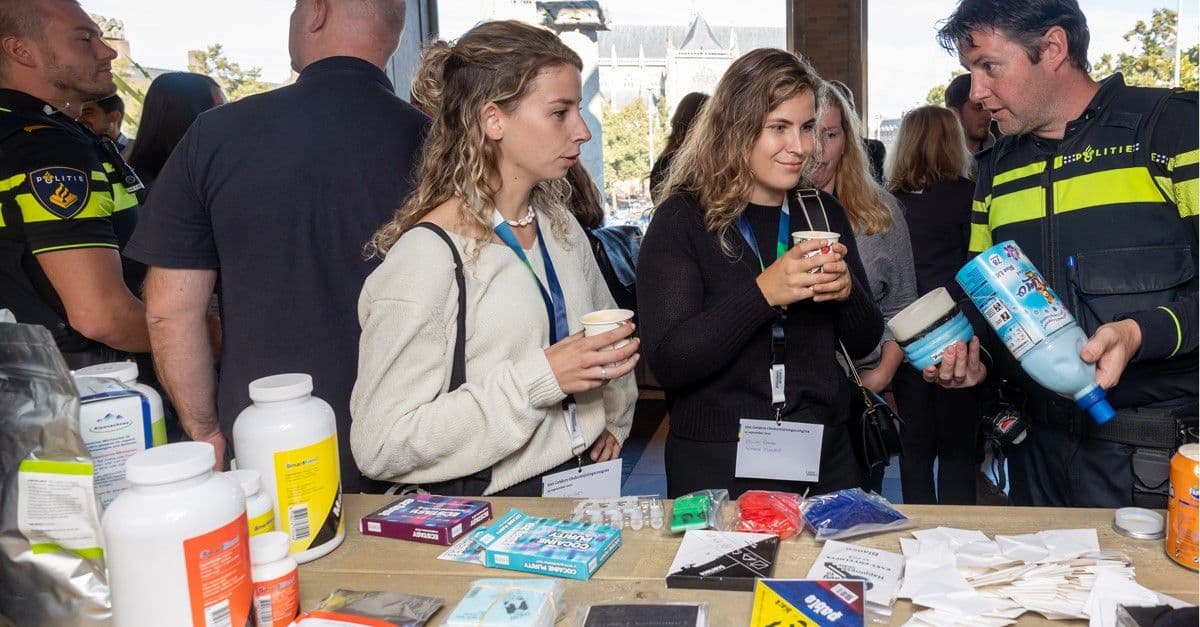 Deelnemers aan de ondermijningsdag in gesprek met een politieman in uniform