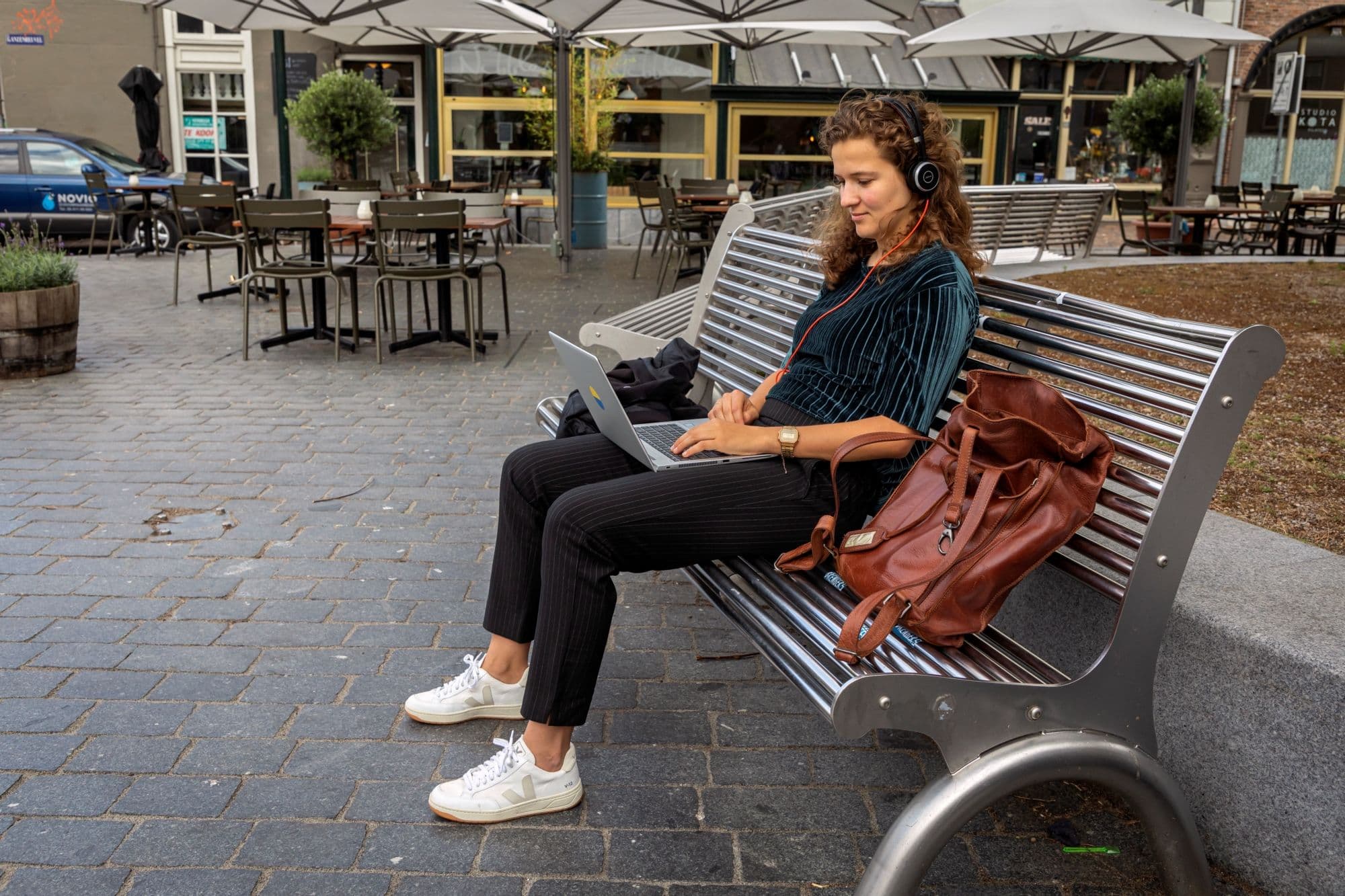 meisje werkt buiten op bankje