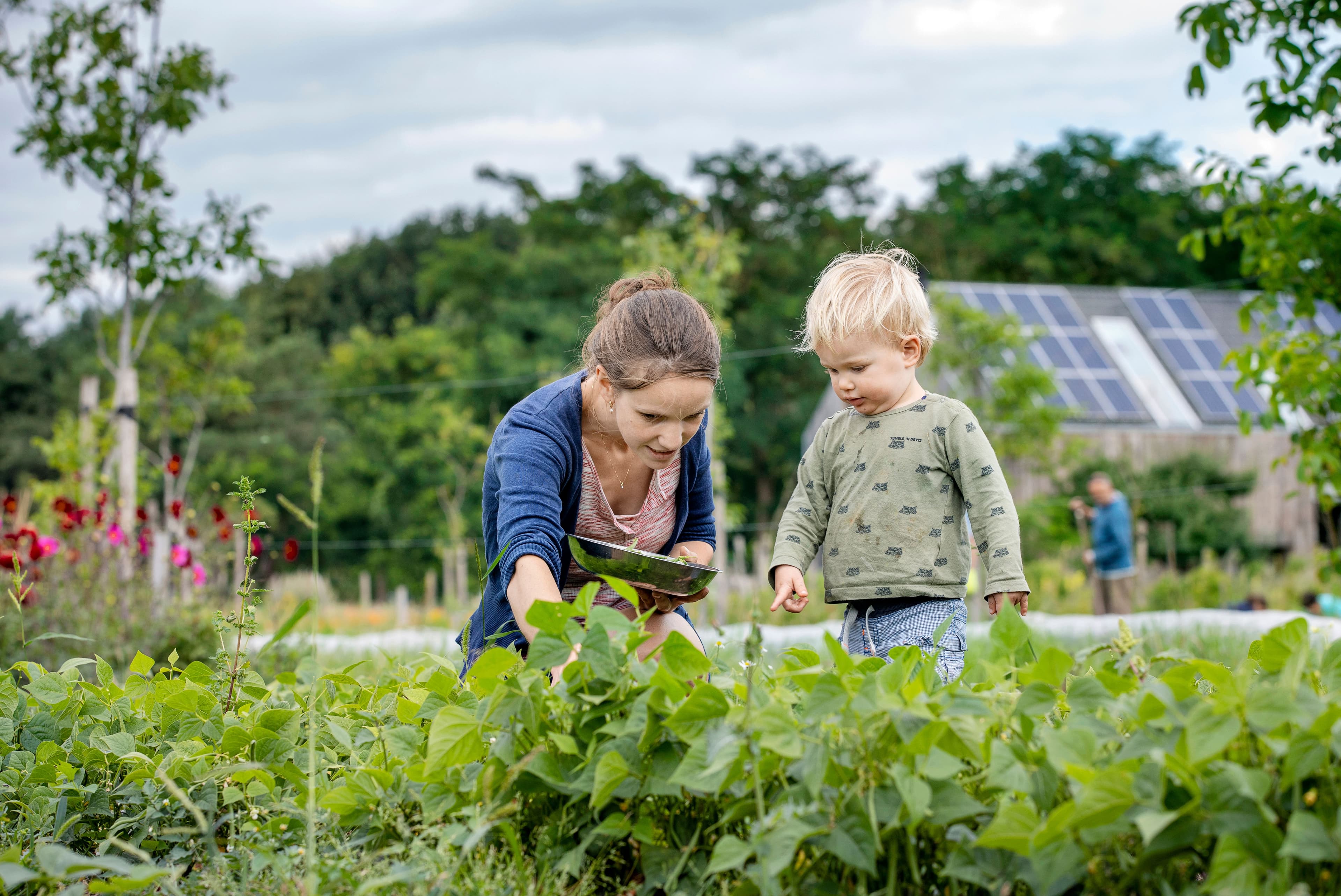 vrouw met kind bij moestuin