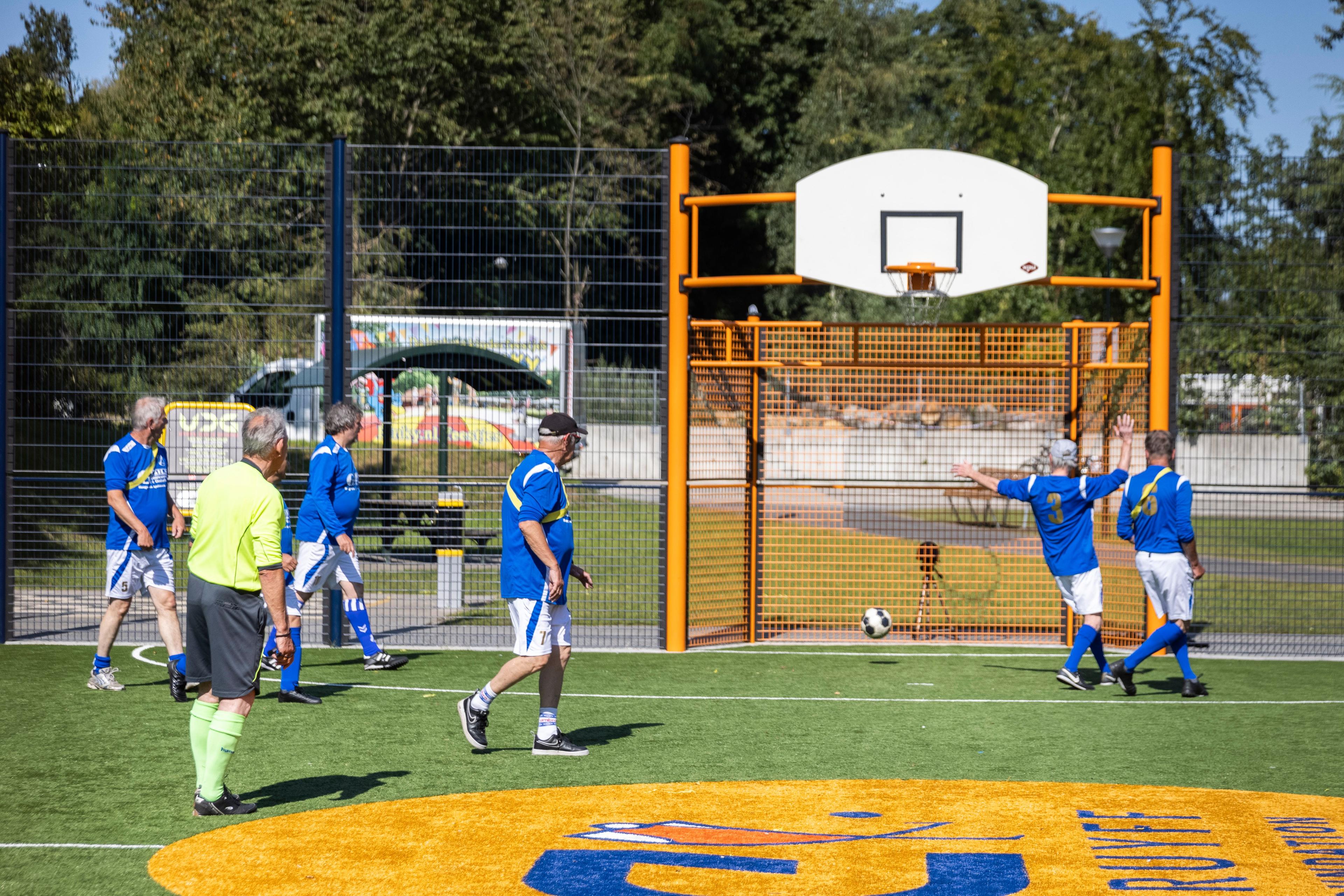 Oudere voetballen op een Cruyff Court