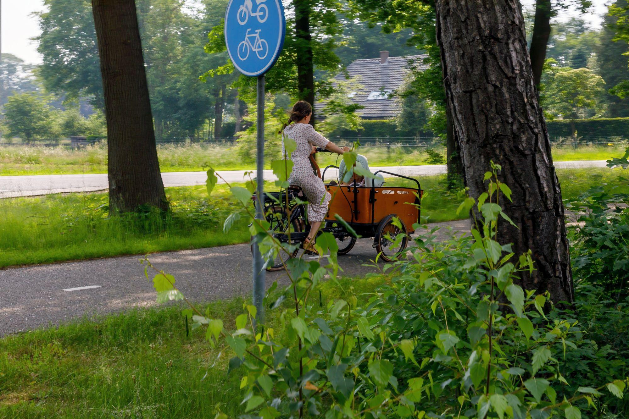 Vrouw met bakfiets op een fietspad