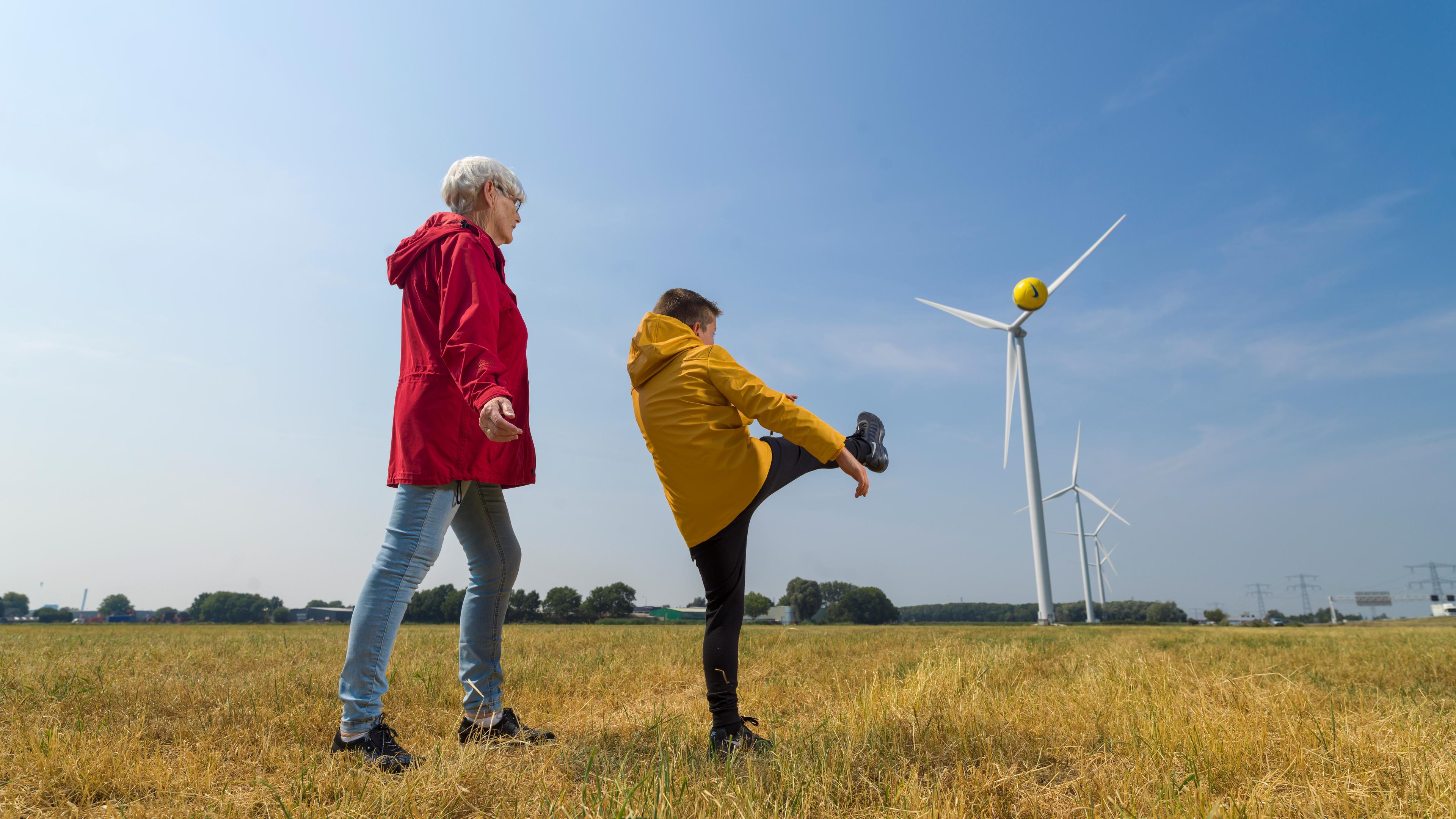 Foto van oma en kleinkind bij een windmolen
